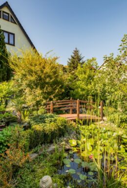 Außenaufnahme Gebäude Ferienwohnung Waldblick und Teich mit Brücke