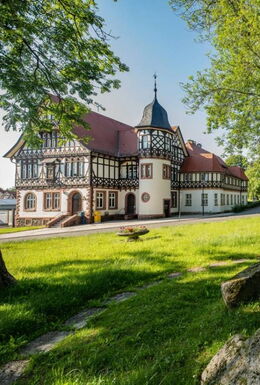 Landschaftsaufnahme mit Historischer Post und Kriegerdenkmal im Vordergrund