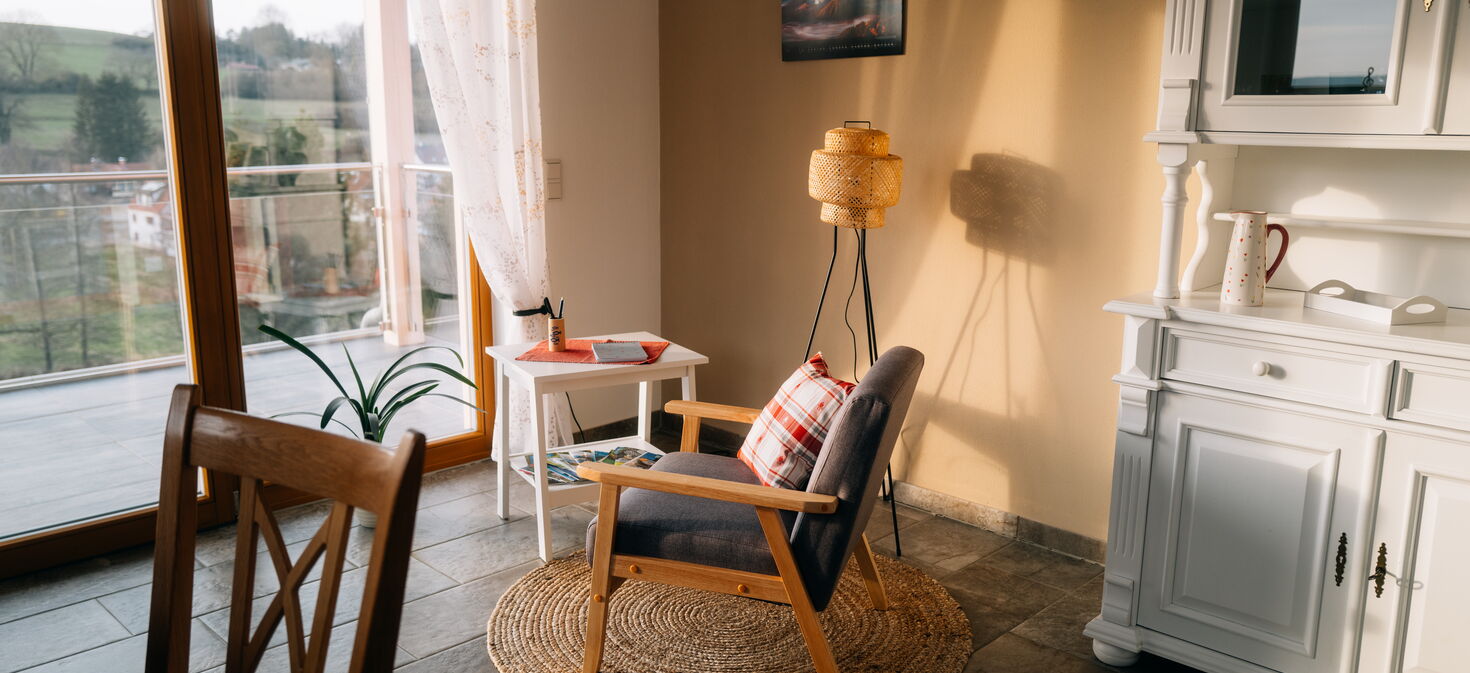 Innenaufnahme mit Sitzecke, Sessel und Blick auf Balkon