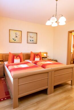 Innenaufnahme Zimmer mit Doppelbett und Stuhl