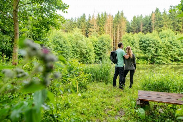 Landschaftsaufnahme im Stillen Tal mit Pärchen und Sitzbank