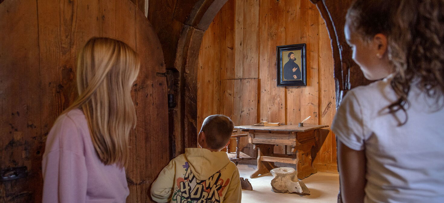 Drei jugendliche Besucher werfen einen neugierigen Blick in die berühmte Luttherstube auf der Wartburg.