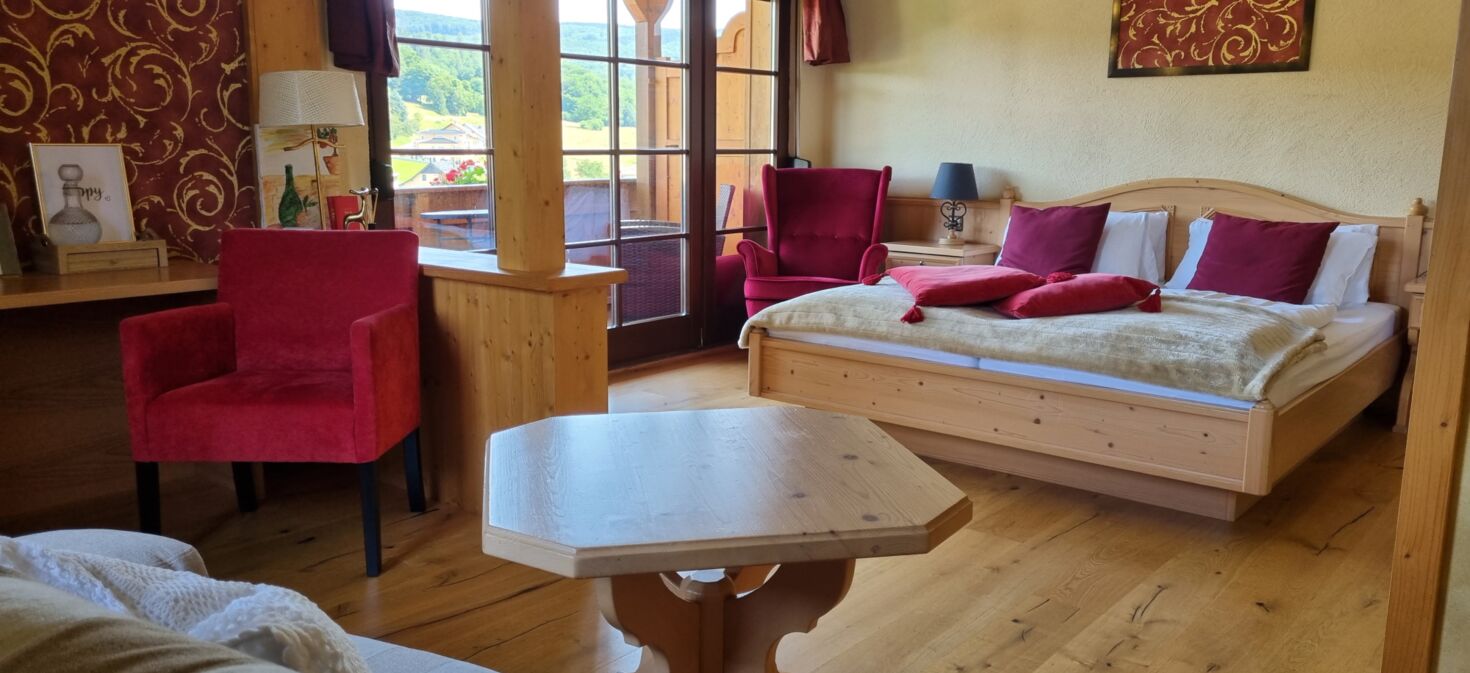 Innenaufnahme Zimmer mit Doppelbett und Sitzbereich