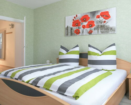 Innenaufnahme Zimmer mit Doppelbett und Kleiderschrank