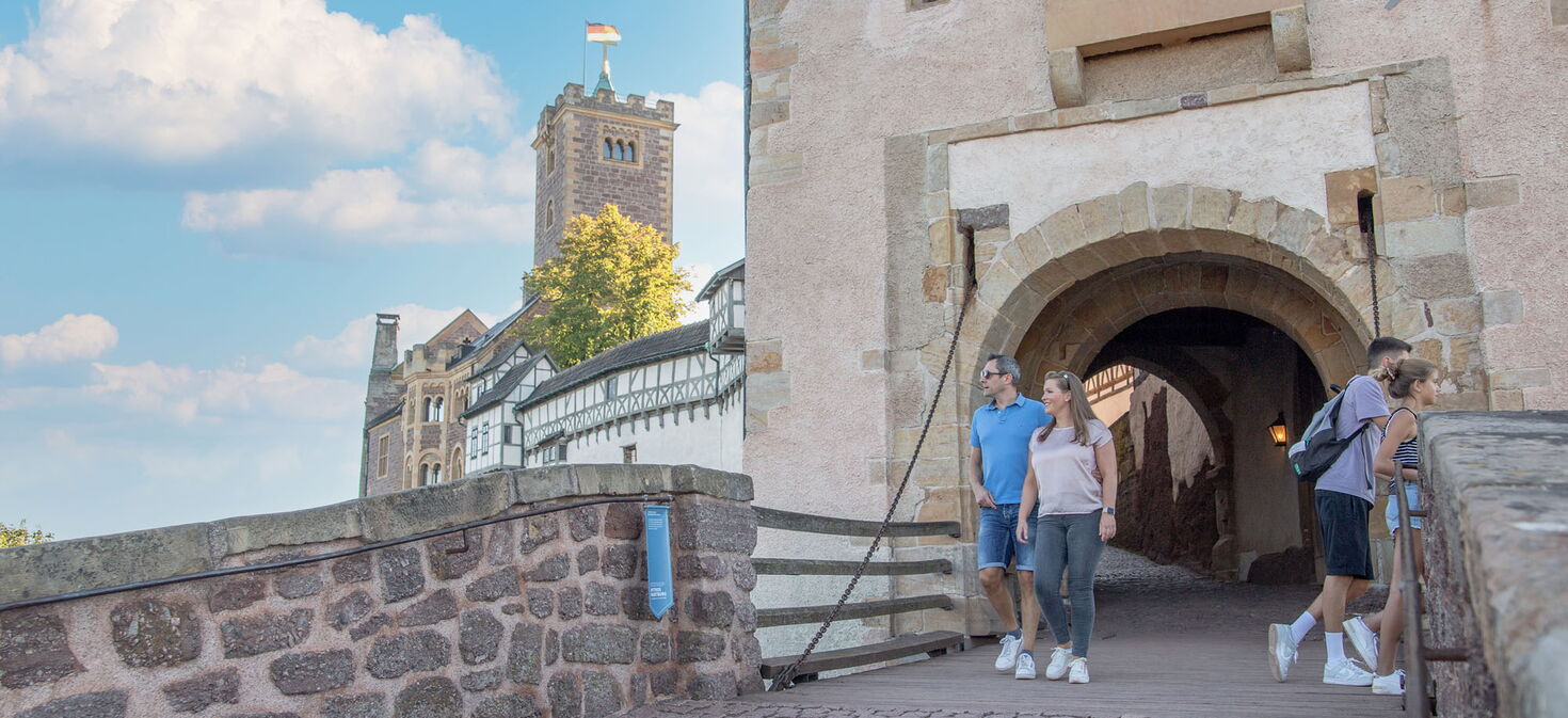 Eine Familie am Eingangstor der Wartburg mit Zugbrücke