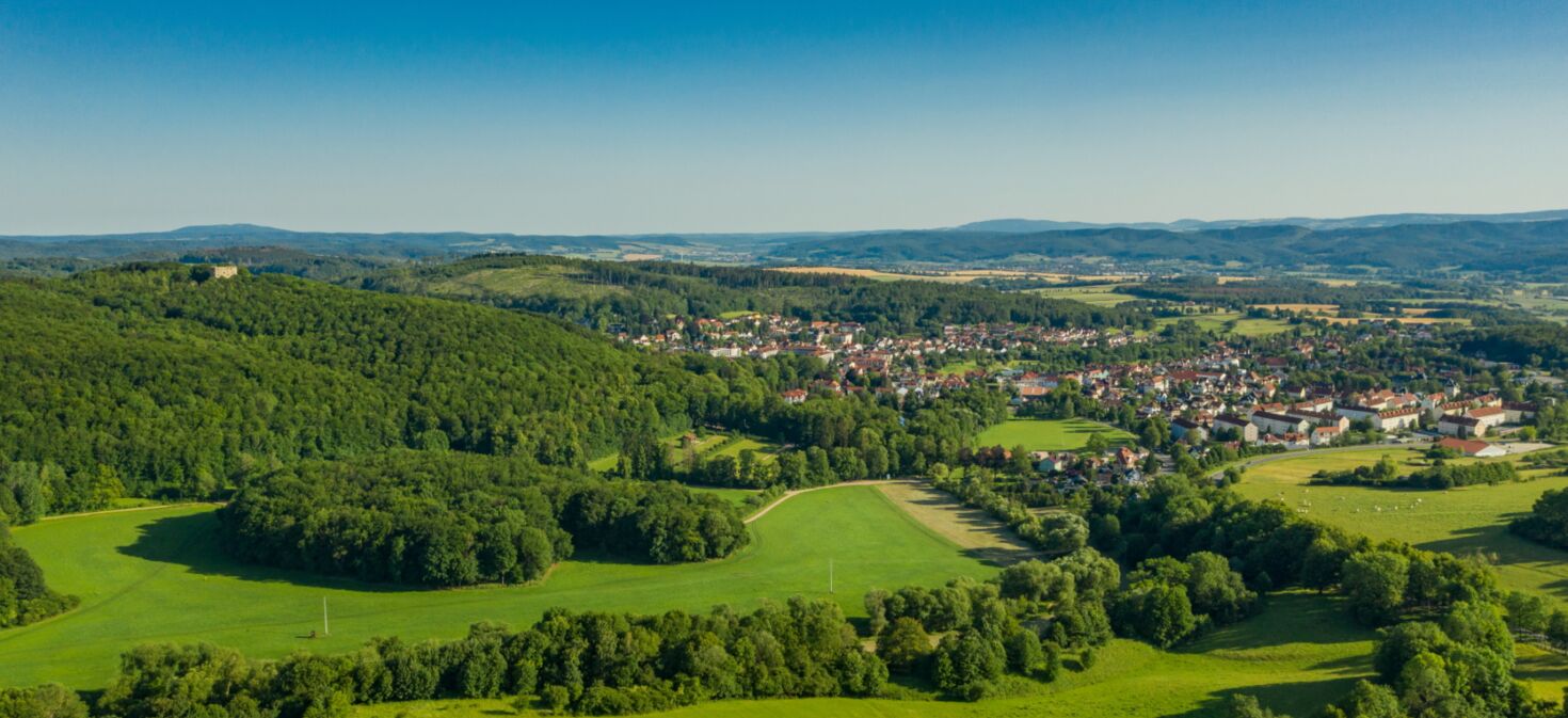 Landschaftsaufnahme mit Blick auf Bad Liebenstein und Burgruine, umgeben von Wald und Natur