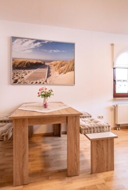 Innenaufnahme Zimmer mit Sofa, TV und Esstisch