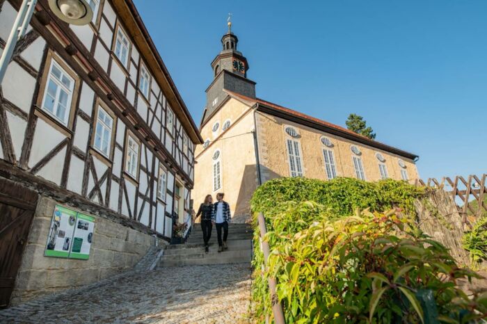 Wanderpaar an der Barockkirche Steinbach und dem Heimatstübchen