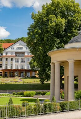 Landschaftsaufnahme mit Brunnentempel, historischem Kurpark und Kulturhotel Kaiserhof im Hintergrund