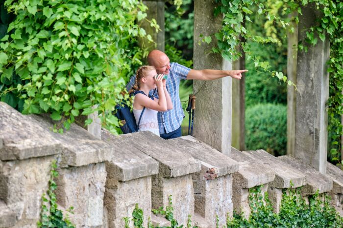 Familie im Schlosspark Altenstein mit Entdeckerrucksack und zugehörigem Parkplan