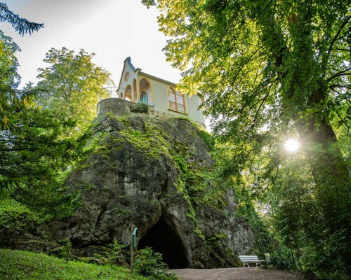 Landschaftsaufnahme Felsen mit Treppen und Höhle, darauf Ritterkapelle im Schlosspark Altenstein
