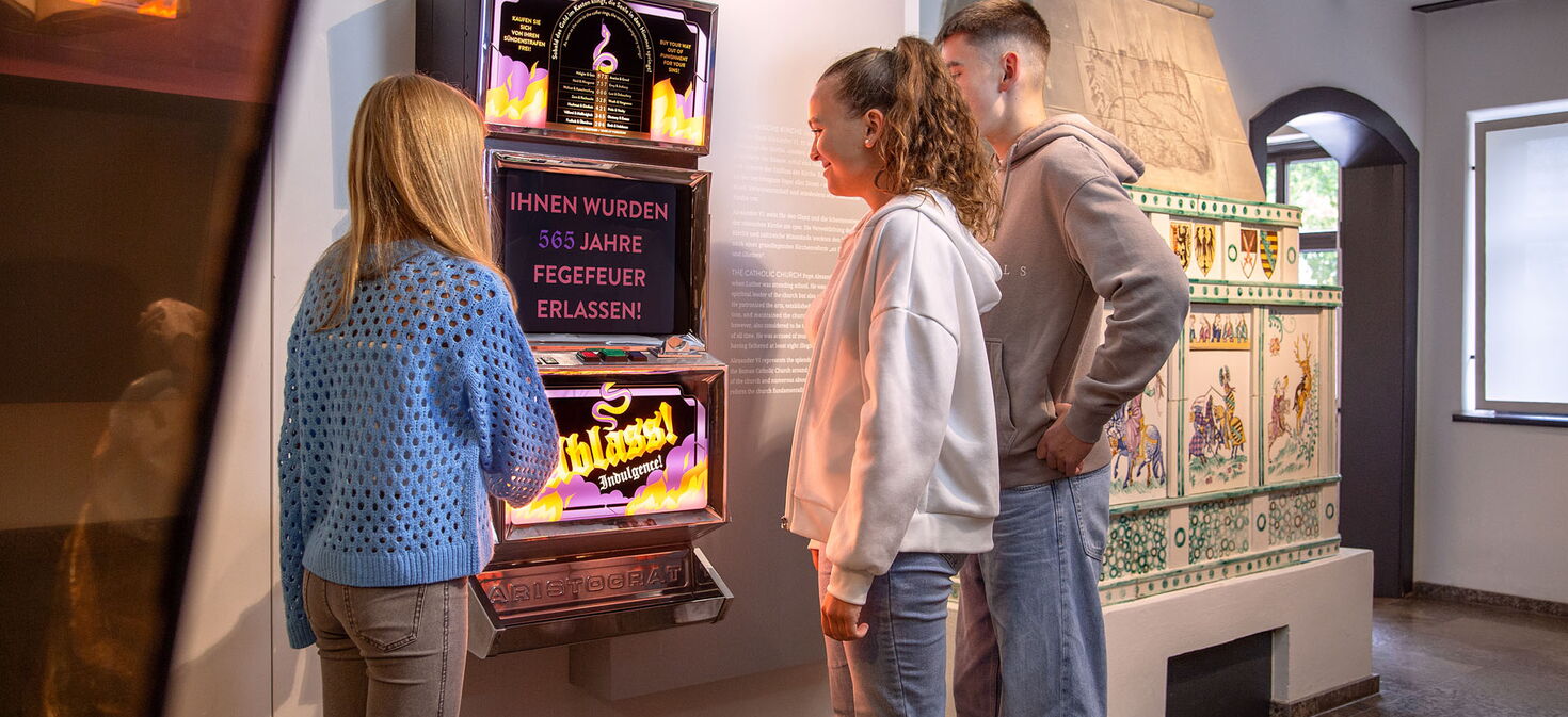 Jugendliche Besucher am Ablassautomaten im Museum Lutherhaus Eisenach