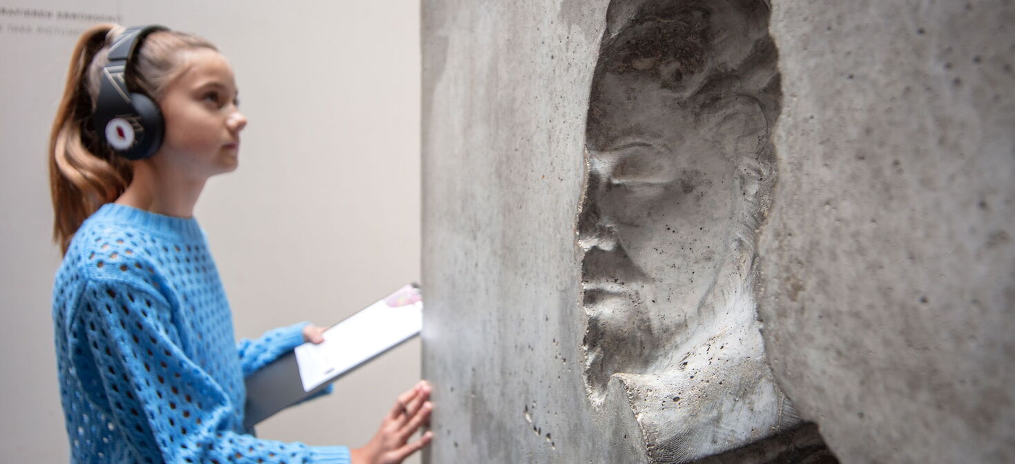 Jugendliche Museumsbesucherin mit Audioguide betractet die Ai WeiWei -Skulptur im Lutherhaus Eisenach