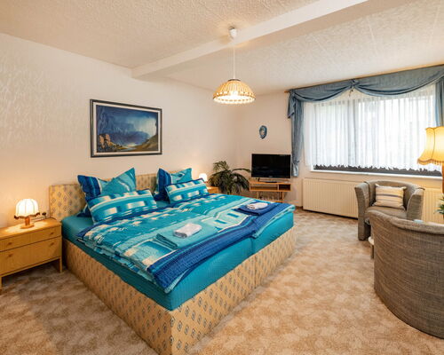 Innenaufnahme Zimmer mit Doppelbett und Sesseln