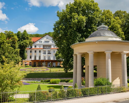 Landschaftsaufnahme mit Brunnentempel, historischem Kurpark und Kulturhotel Kaiserhof im Hintergrund