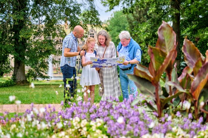 Familie im Schlosspark Altenstein mit Entdeckerrucksack und zugehörigem Parkplan