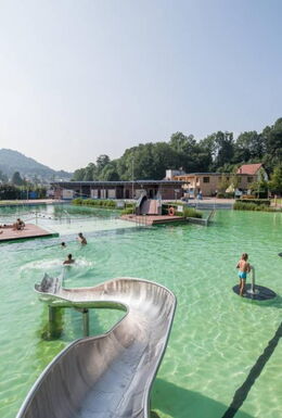 Aufnahme des Freibades BioBad Glücksbrunn mit Wasserrutsche, Wasserkanonen, und Liegeflächen