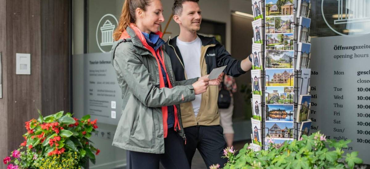 Eingangsbereich der Tourist-Informationen mit Pflanzkübeln und Postkartenständer