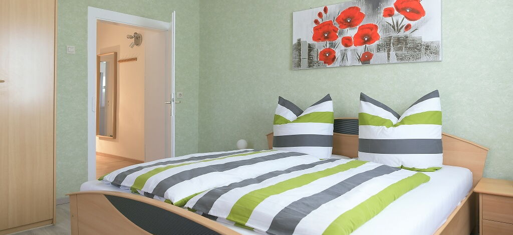 Innenaufnahme Zimmer mit Doppelbett und Kleiderschrank