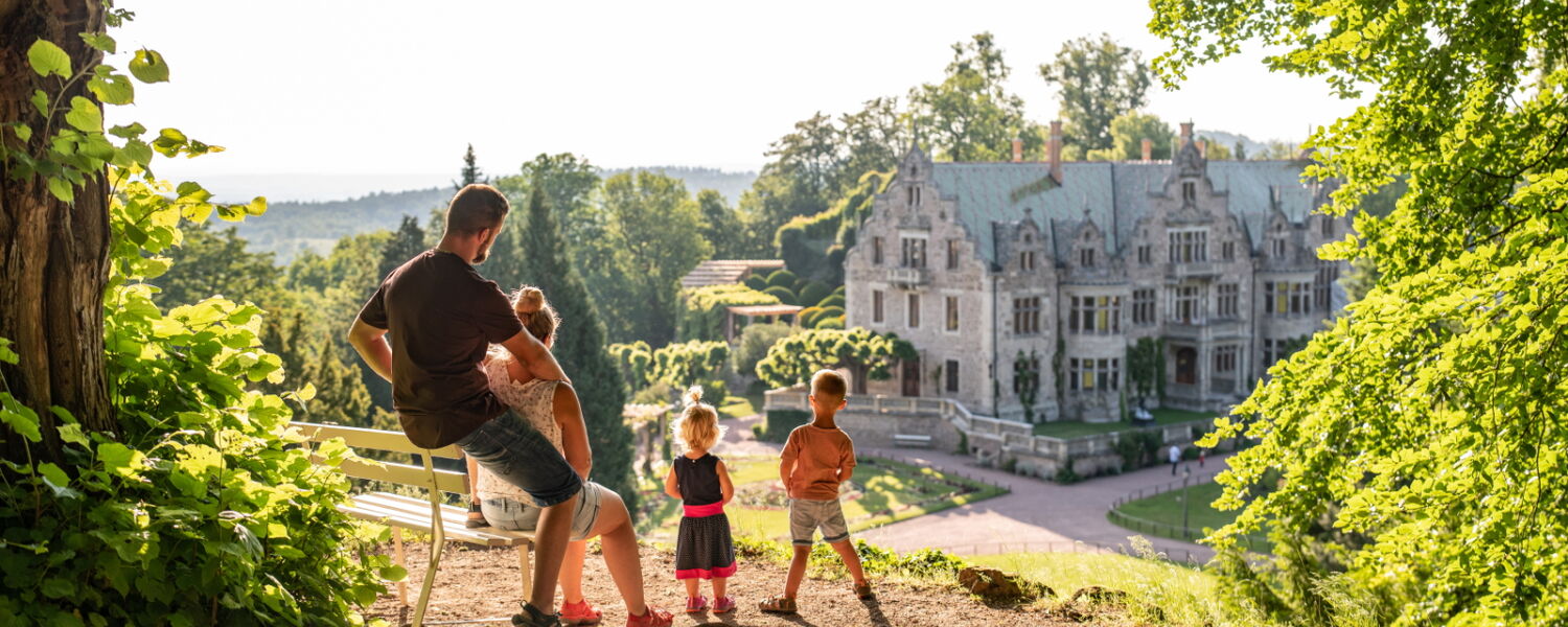 Familie, die vom Bonifatiusfelsen auf Schloss Altenstein im Schlosspark Altenstein blickt