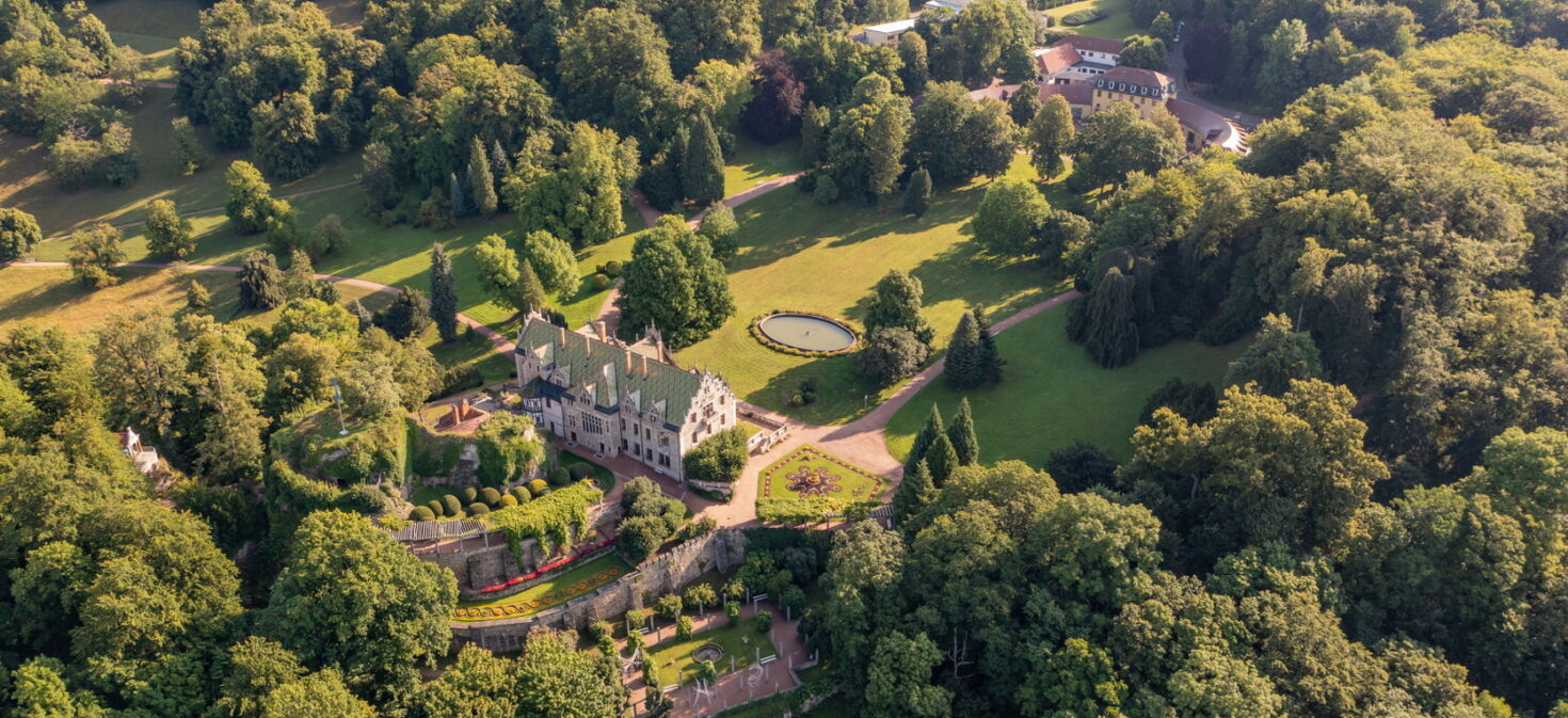 Luftaufnahme Innenpark Schloss & Park Altenstein mit Eingangsbereich, Schloss und Beetanlagen, umgeben von Wald und Natur