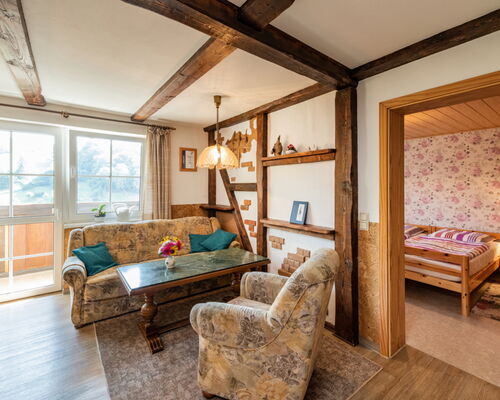 Innenaufnahme Zimmer mit Sofa, Sessel, Fachwerk, Balkon
